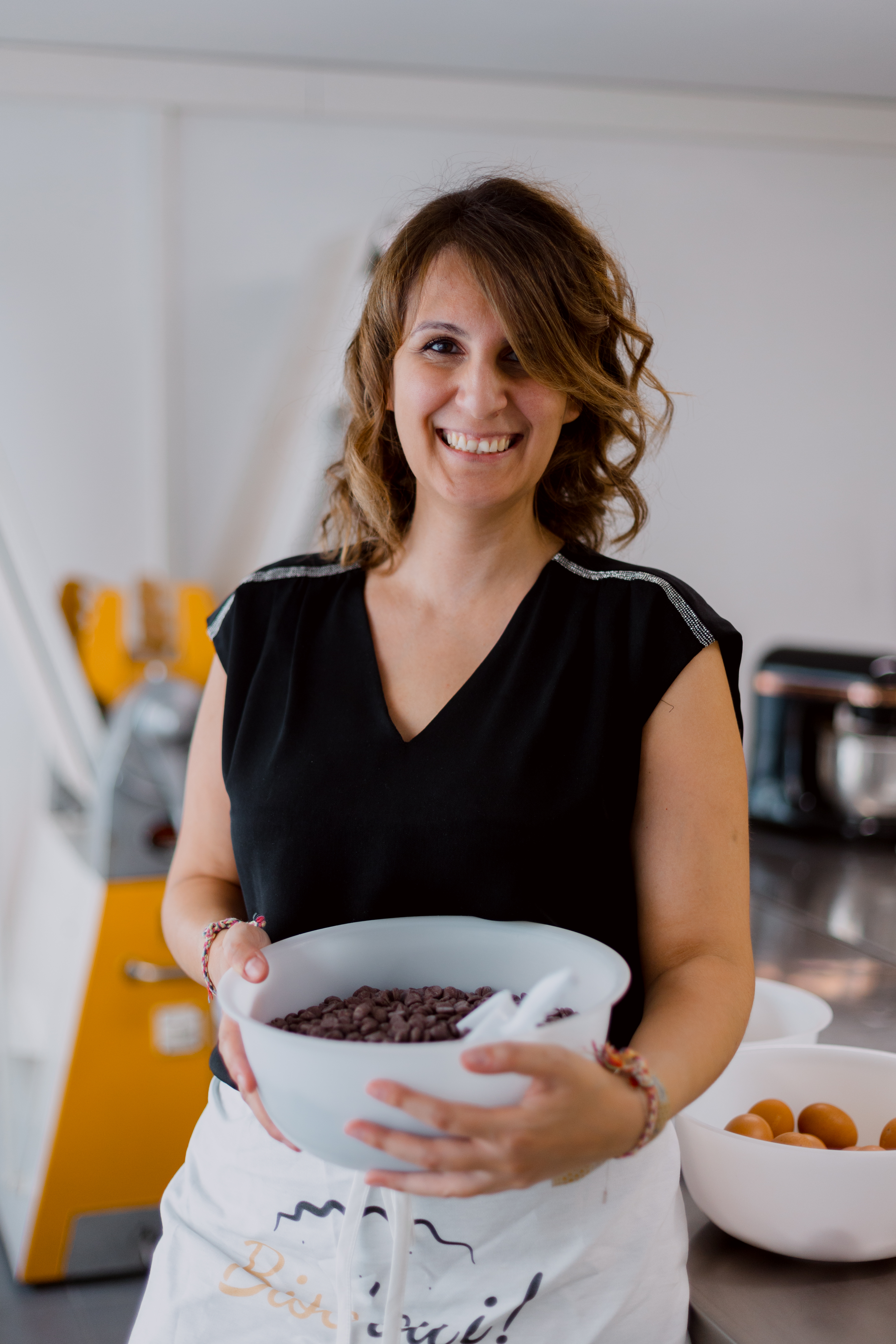 Cynthia, créatrice de Bisc'Oui, tenant un bol de pépites de chocolat, prête à concocter ses délicieux cookies a