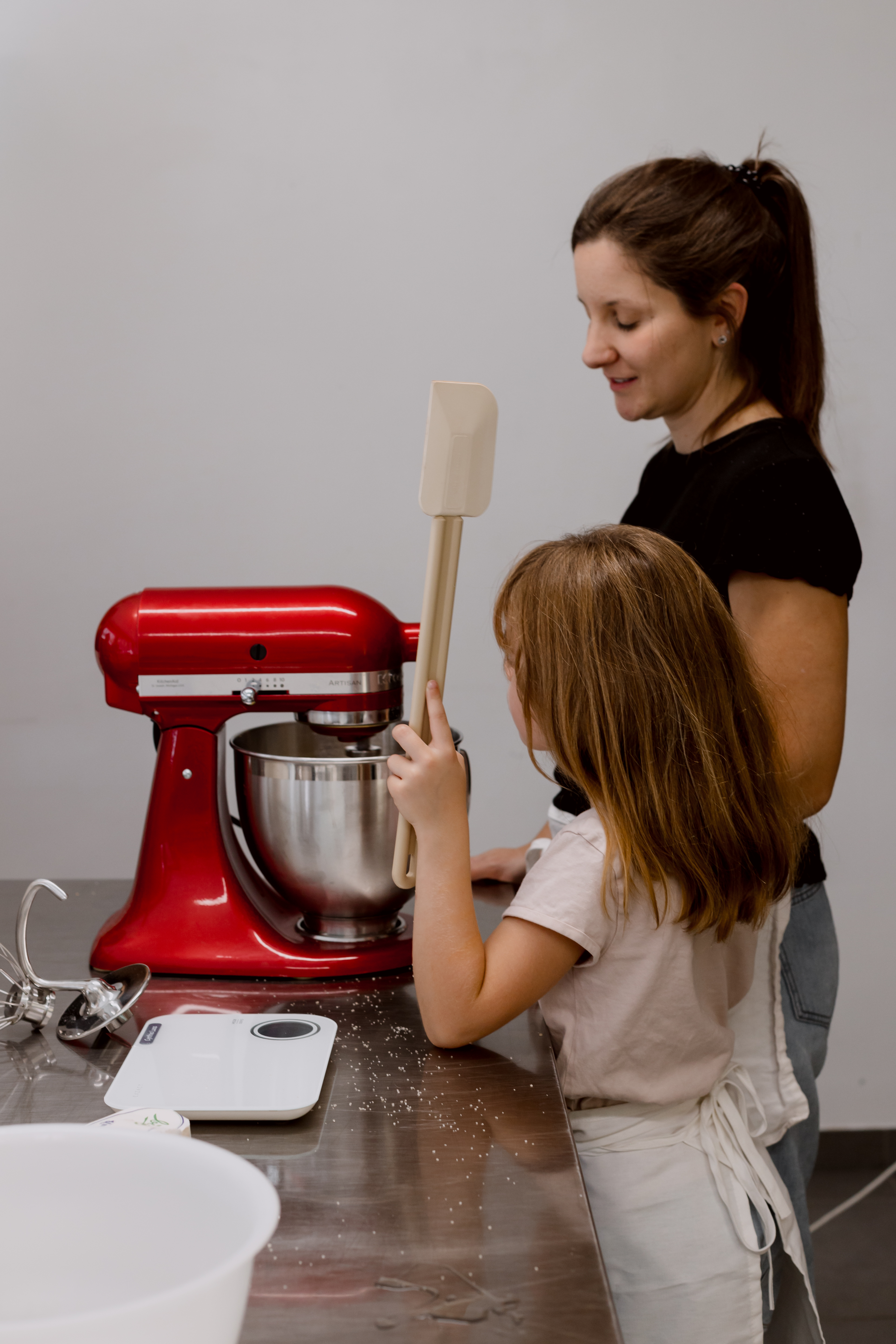 Une femme et une petite fille préparant des cookies ensemble dans une cuisine, partageant un moment de pâtisserie joyeux.